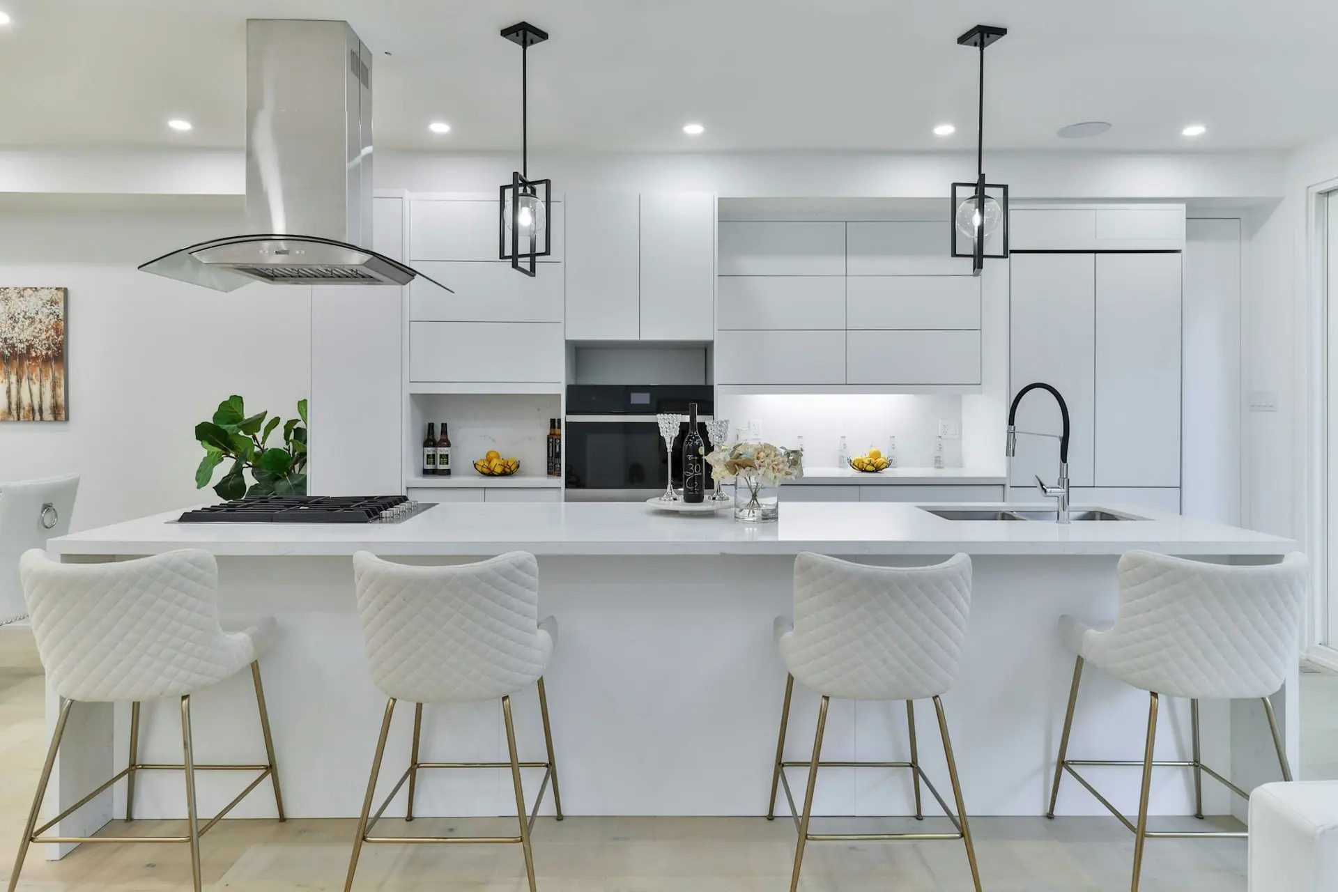 Bright white modular kitchen with a long quartz island, bar stools and handleless cabinets