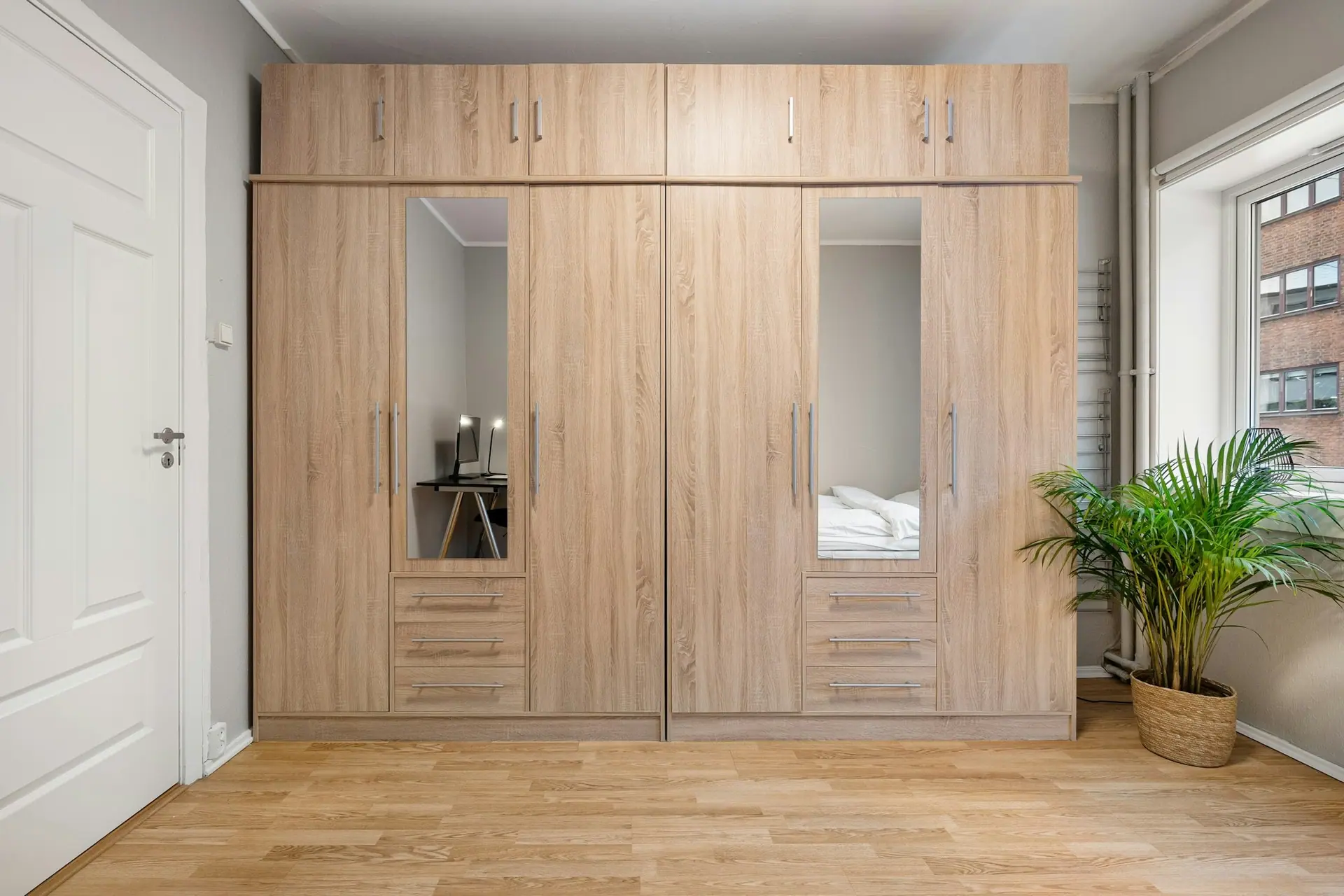 Light oak fitted wardrobe with hinged doors, mirror panels, drawers and loft cabinets